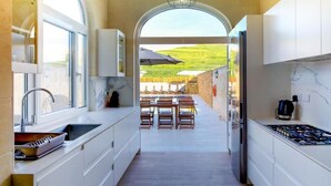 Une cuisine moderne donnant sur un patio extérieur et une piscine.