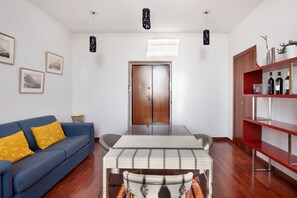 Una sala de estar moderna con un sofá, una mesa de comedor y una estantería.