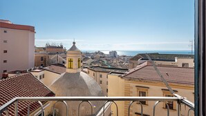 Un paisaje urbano con edificios, cielo despejado y una vista distante del mar.