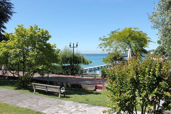 Un parque con un banco, un sendero, un puente y vistas al agua.