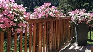 Un balcon en bois offrant une vue sur un paysage montagneux.