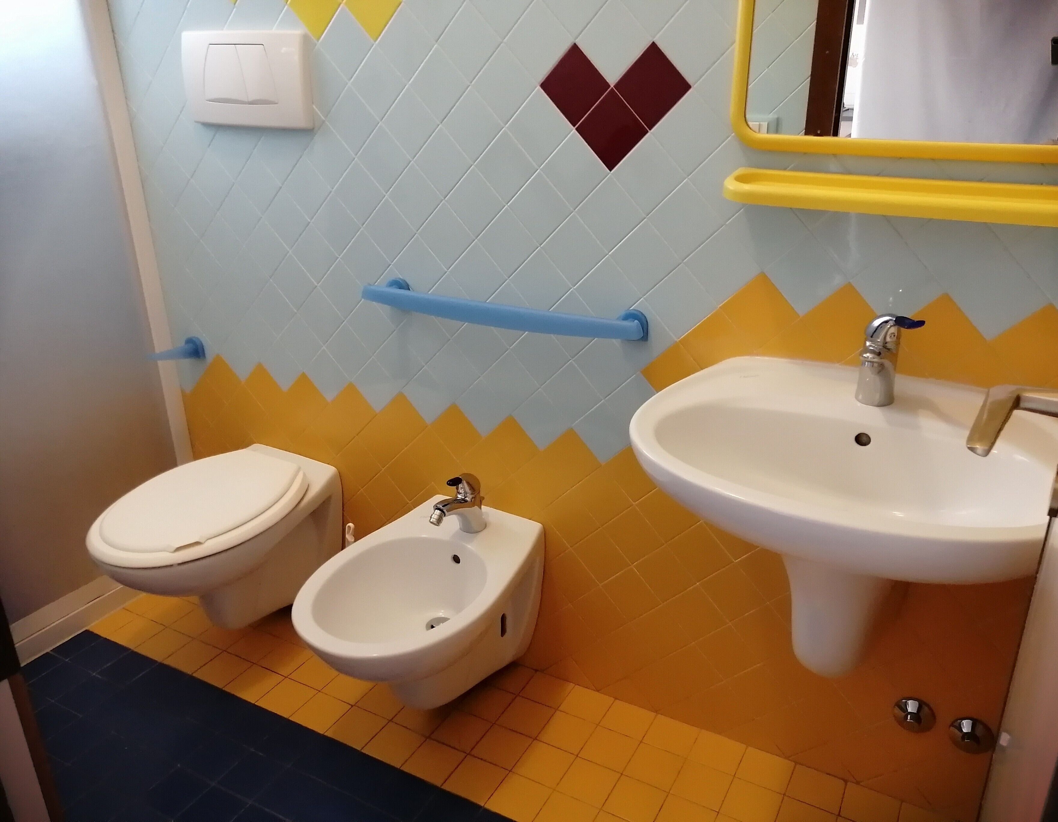 A bathroom with a toilet, bidet, and sink.