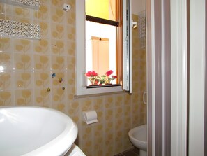 Une salle de bain comprenant des toilettes, un lavabo, une fenêtre avec vue et un espace douche.