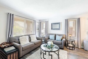 A modern living room with two sofas, a coffee table, and a side table.