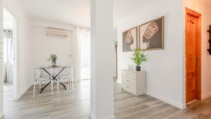 Ein modernes Interieur mit einem Esstisch, Stühlen, einer weißen Kommode und zwei gerahmten Kunstwerken an der Wand.