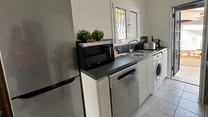 A modern kitchen with stainless steel appliances, a dishwasher, a microwave, and a sink. - Holiday Home 'El Pozo - 400m from Riells Beach' with Terrace, Garden and Balcony (L'Escala)