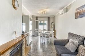 Una sala de estar con un sofá gris, una mesa de centro de madera y una chimenea.