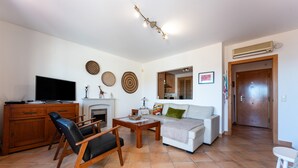 Ein Wohnzimmer mit Fernseher, Holzmöbeln, Kamin und einer Couch.