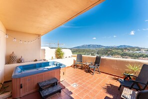 Un bain à remous, des chaises de patio et une vue sur les montagnes.