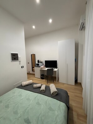 Une chambre d’hôtel moderne équipée d’un lit, d’un bureau et d’une armoire.