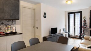 A modern living space with a dining area, a television, and a Christmas tree. - Apartment 'Giorgia - Caspoggio' with Mountain View, Shared Garden and Balcony (Caspoggio)