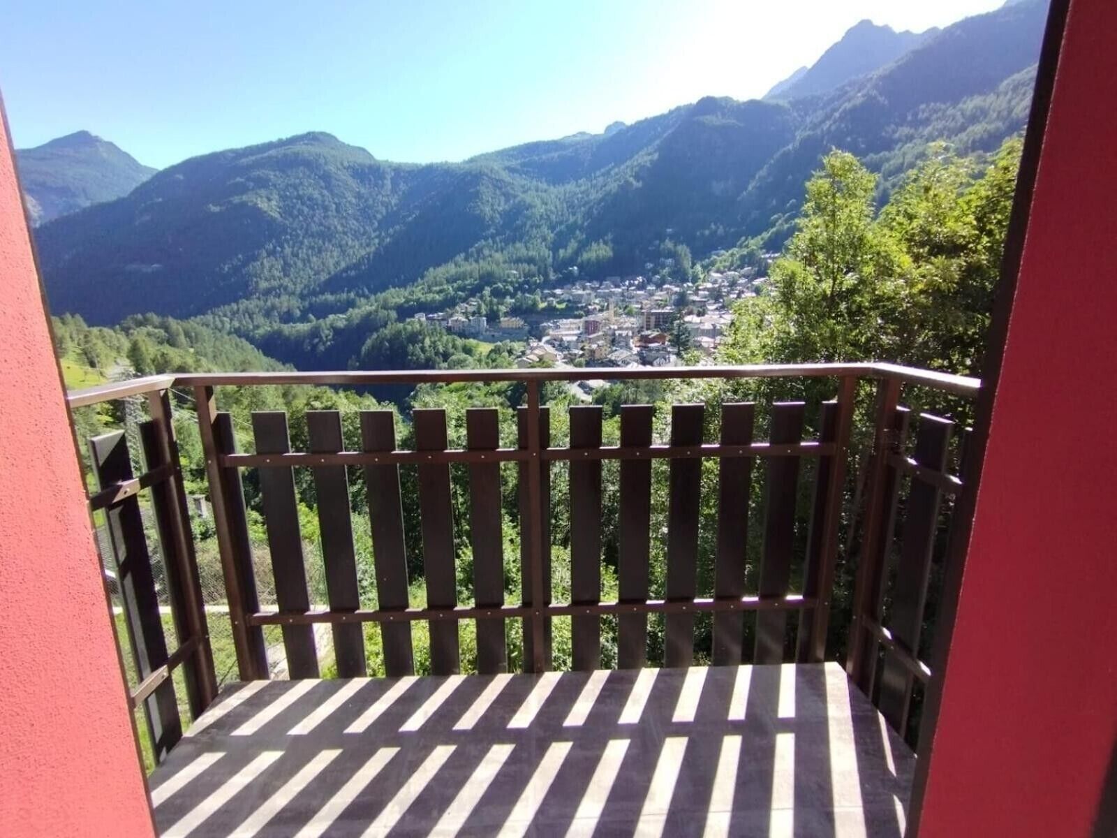 A balcony with a view of a valley and mountains.