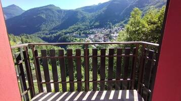 A balcony with a view of a valley and mountains.
