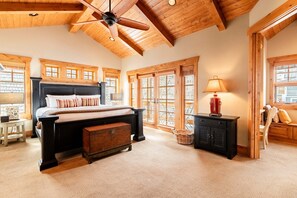 A bedroom with a large bed, wooden ceiling beams, and a ceiling fan. - Park City Main Street Powder Lodge / Pool Table, Ski Access, Chef (Park City)