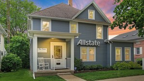 A two-story house with a front porch, a sign reading "Allstate," and a mailbox. - Neighboring suites in central heart of town! Perfect for couples! Walk to Town, Balcony, & Parking (Lake Geneva)