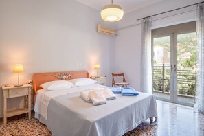 Une chambre d’hôtel avec un lit, des lampes de chevet, une chaise et un balcon avec vue.