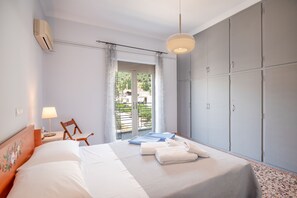 A bedroom with a bed, a chair, a desk, a wardrobe, and a window with a view. - Giorgos House: Holiday Home in Nafpaktos, Near beach, taverns, WiFi (Lagathoula)