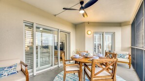 A dining area with a round table, wooden chairs, and a ceiling fan.