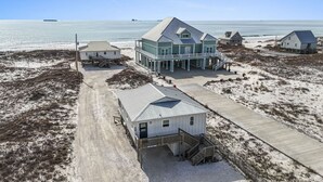 A coastal property with a main house, a smaller building, and a pier extending into the water. - Steps to Sand on Private Beach | Cozy 2BR Cottage (Gulf Shores)