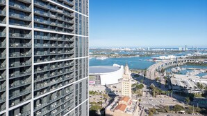 A high-rise building with multiple balconies, a waterfront view, a bridge, and a stadium. -  3012 - Studio in front of Kaseya Center with Pool and Gym (Miami)