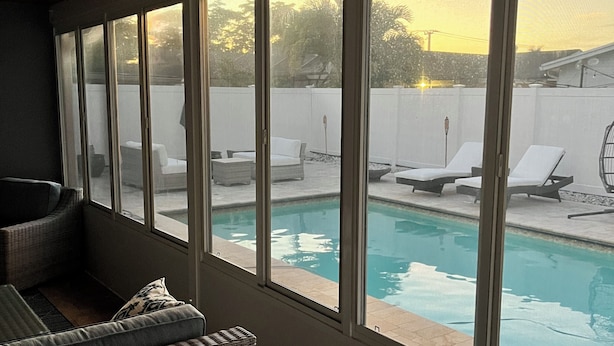 A room with a view of a swimming pool, wicker furniture, and a wooden ceiling. - Charming 3-bedroom house with Pool, Washer and Dryer and Garage in Boca Raton (Boca Raton)
