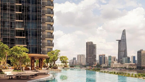 A modern hotel with a rooftop infinity pool overlooking a city skyline. - Metropole Residences Luxury Suite (Ho Chi Minh City)