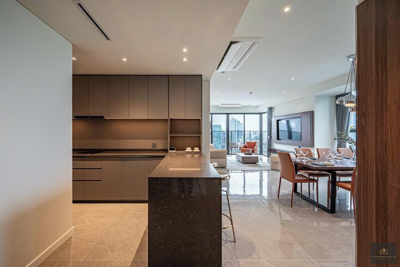 Una cocina moderna con una isla central, armarios empotrados y un comedor con un amplio ventanal con vistas a la ciudad.