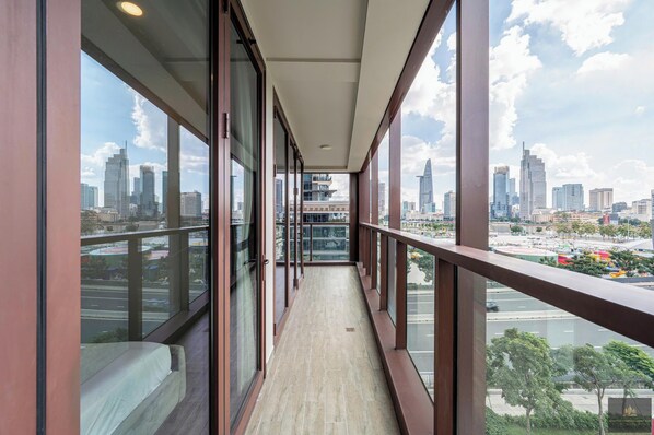 A corridor with large windows offering a city view.