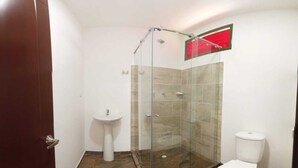 A bathroom with a glass-enclosed shower, a pedestal sink, and a toilet.