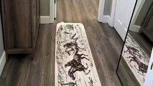 Un pasillo estrecho con piso de madera que conduce a un dormitorio con cama y mesita de noche.