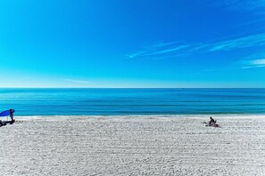 En strand med klar himmel og roligt hav.