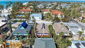 A coastal residential area with houses, a beach, and a clear sky. - The Magic Dolphin B, great Holmes Beach location, steps to gulf beaches (Holmes Beach)