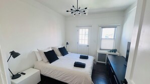 A bedroom with a bed, bedside tables, a desk, a chair, a window, and a ceiling light fixture. - 🌇DoWnToWn HoUsE🏡 / 3min WALK to TrainSTATION & facilities / Clean-Spacious-Quiet (Harrison)