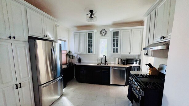 A kitchen with white cabinets, stainless steel appliances, a black stove, and a ceiling fan. - 🌇DoWnToWn HoUsE🏡 / 3min WALK to TrainSTATION & facilities / Clean-Spacious-Quiet (Harrison)