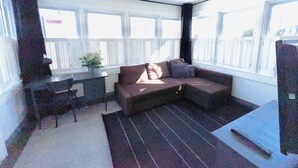 A sunlit room with a sofa, a small table, and a potted plant. - 🌇DoWnToWn HoUsE🏡 / 3min WALK to TrainSTATION & facilities / Clean-Spacious-Quiet (Harrison)