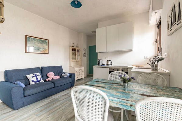 A compact living space with a sofa, dining table, and kitchenette.