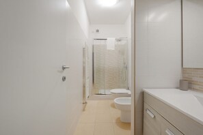 Regadera, secadora de cabello, bidet, toallas