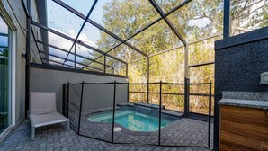 Ein Whirlpoolbereich im Freien, umgeben von Glas, mit einer Holzbank und einer Steinarbeitsplatte.