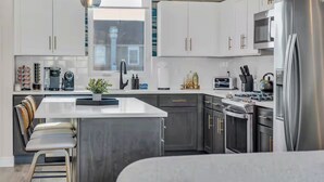 Een moderne keuken met witte kasten, roestvrijstalen apparatuur en een centraal eiland.