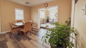 A dining area with a table and chairs, a potted plant, and a view into the living room. - Relaxing 2BR/2BA Entire House, Short Drive from Wildwood & Cape May Beaches (Middle Township)