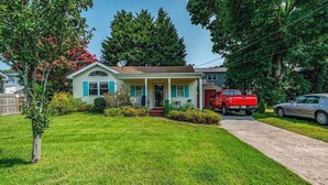 A single-story house with a front porch, a red truck parked in the driveway, and a car parked on the street. - Relaxing 2BR/2BA Entire House, Short Drive from Wildwood & Cape May Beaches (Middle Township)