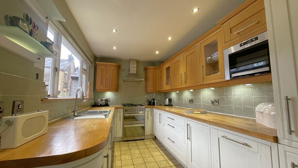 A modern kitchen with wooden cabinets, a built-in oven, and a microwave. - 45 Eskin Street  - sleeps 6 guests  in 3 bedrooms (Central Keswick)