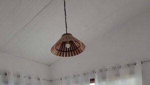 Un lit bien fait, avec une tête de lit en bois, une literie blanche et une serviette pliée posée sur le côté.