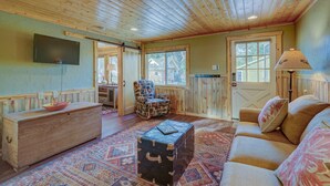 A cozy room with a wooden ceiling, a sofa, a patterned rug, a wooden chest, and a chair. - Serene River Place Retreat Unit 2, 1-bedroom condo nestled along the river in Howard, CO. (Howard)