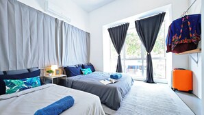 A hotel room with two beds, a desk, a window with curtains, and a suitcase. - Cosy Batu Kawan Homestay 12 pax ~ 5 mins to Design Village & IKEA ~ Entire Home (Simpang Ampat)