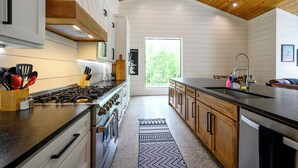 Una cocina moderna con armarios de madera, una isla grande y vistas al exterior.