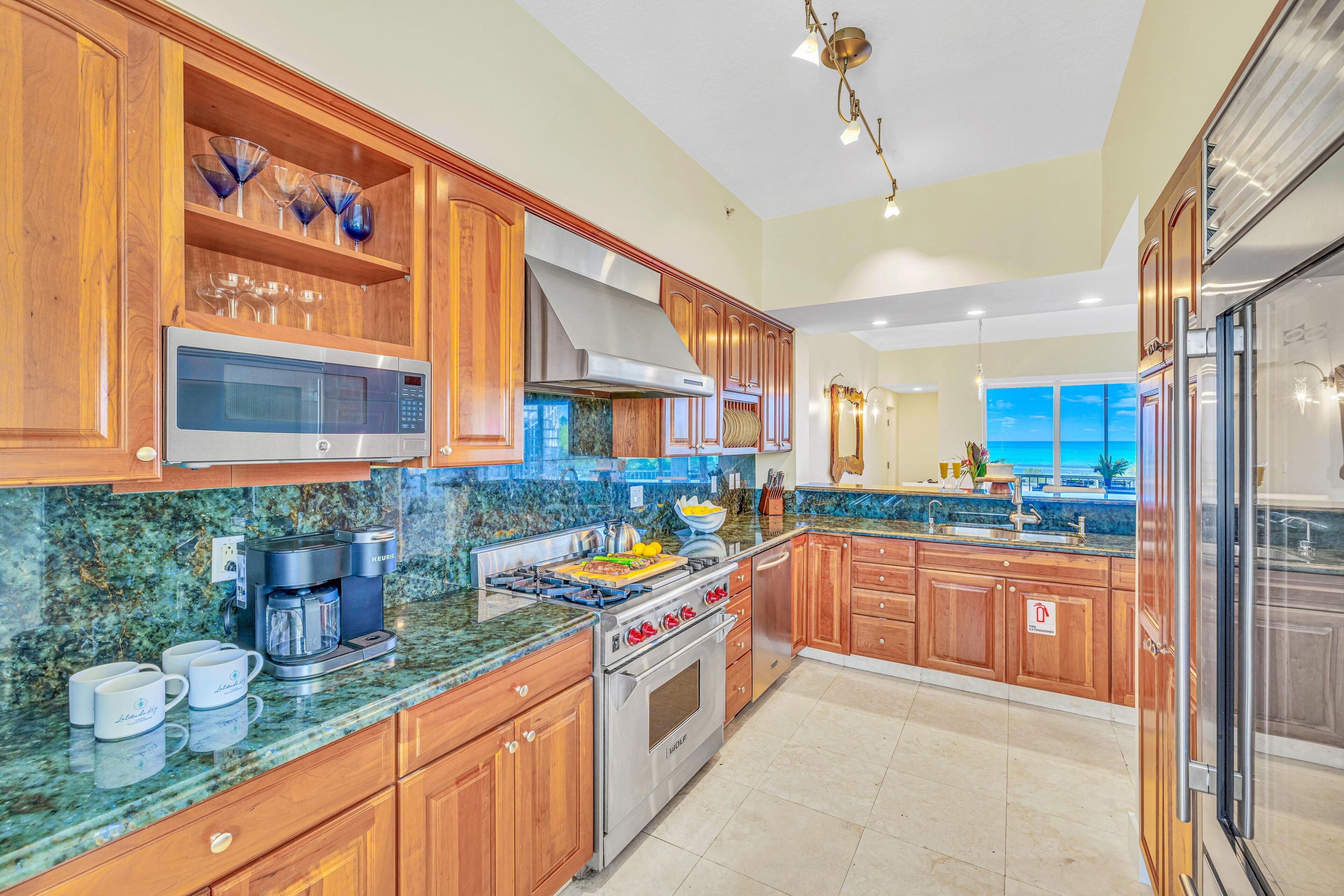 A modern kitchen with wooden cabinets, a stainless steel stove, a microwave, and a coffee maker.