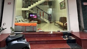 Een hotelentree met een trap die leidt naar een lobby met een bank, een televisie en een tweede trap.