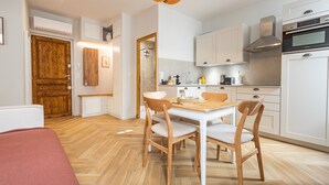 A modern kitchen with white cabinets, a wooden dining table, and chairs. - Luxurious Retreat in Old Antibes & beach (Antibes)