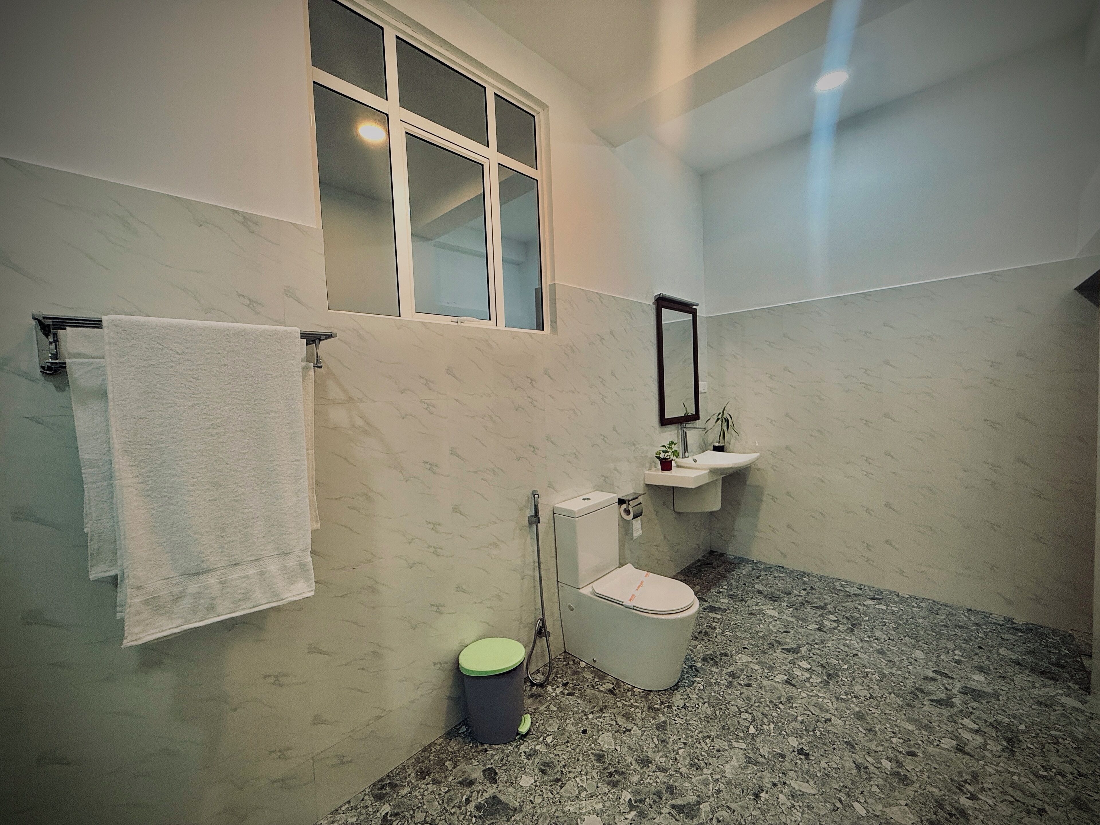Un baño con inodoro, lavamanos y ventana.